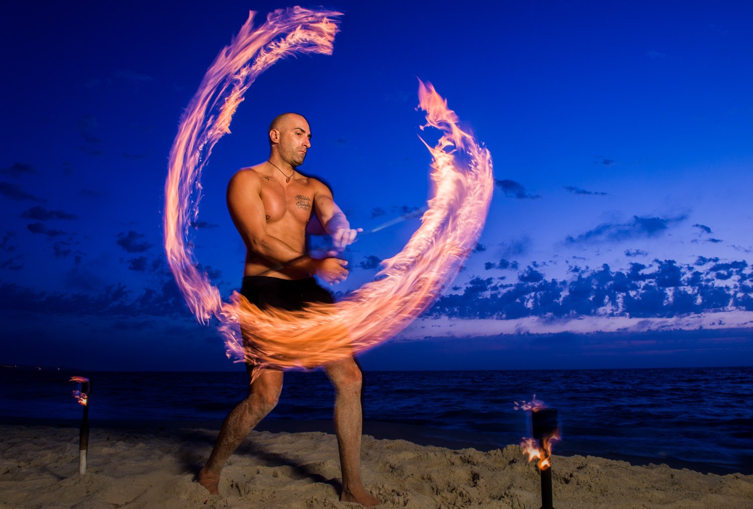 Fire performer on the beach at dusk